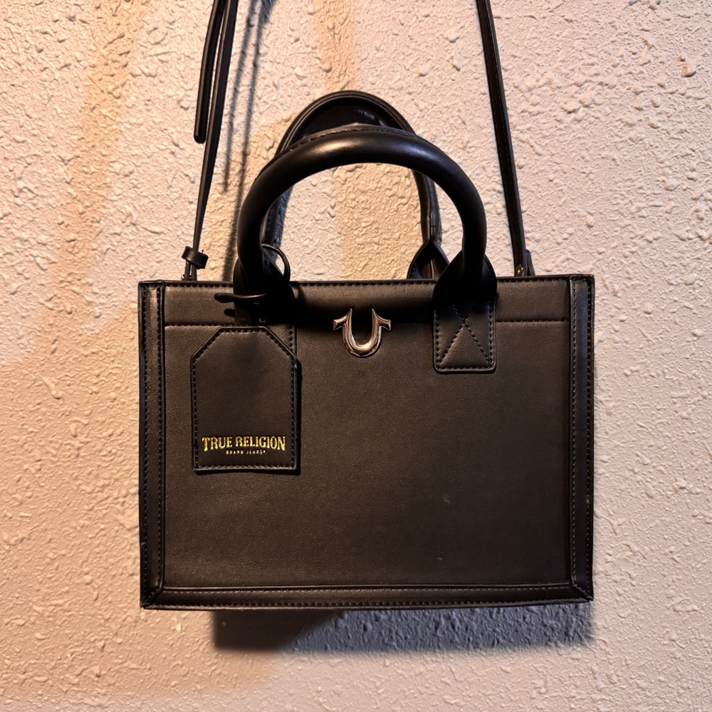 Black True Religion faux leather medium tote bag with an adjustable strap.